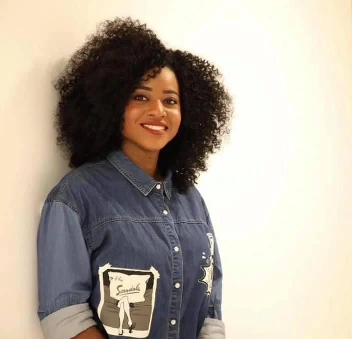 Mimi smiling in a denim shirt