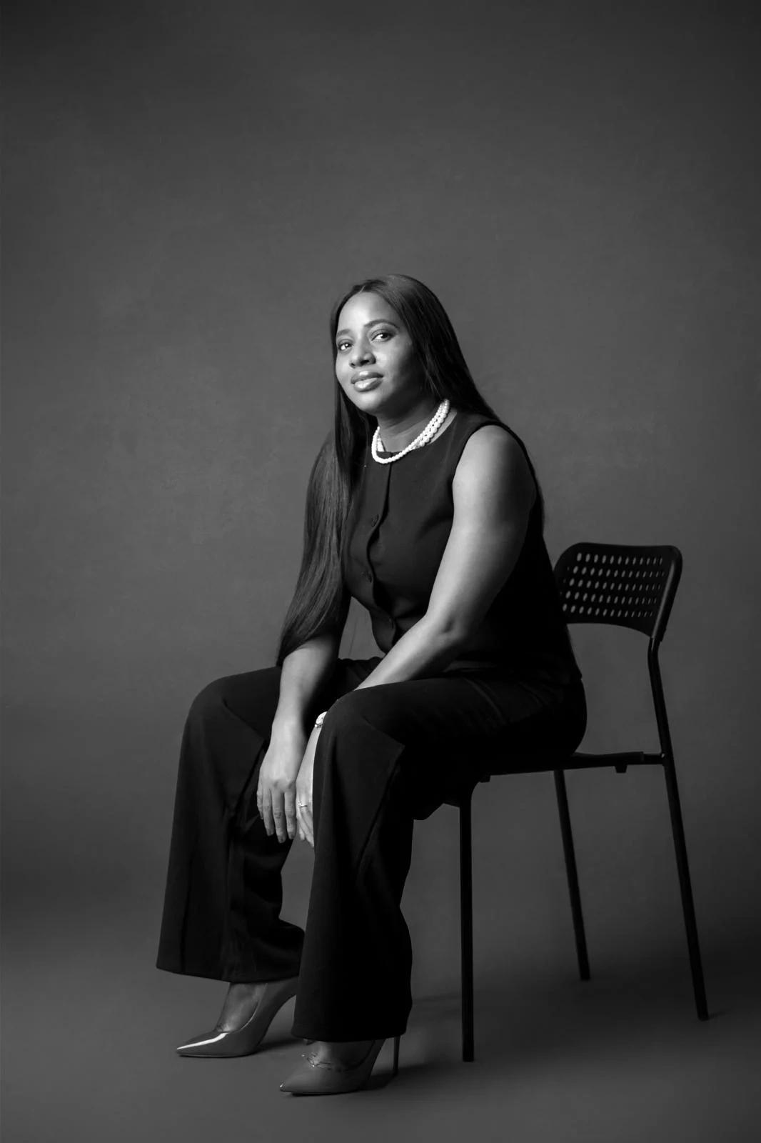 Mimi seated in a monochrome studio portrait